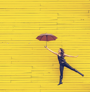 Frau mit offenem Schirm auf gelbem HIntergrund